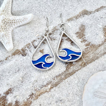 Load image into Gallery viewer, Curling Wave Earrings are displayed by being placed on top of a sand covered driftwood.