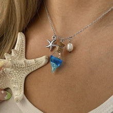 Load image into Gallery viewer, Drift Bottle Starfish Necklace displayed by being worn around a woman's neck.