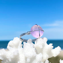 Load image into Gallery viewer, Hand-Wired Pink Sea Glass Ring is sitting on top of a dried white artificial coral against a blurred beach background.