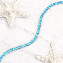 Load image into Gallery viewer, Ocean Blue Zircon Tennis Bracelet displayed on a white wooden surface.