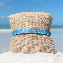 Load image into Gallery viewer, Opal Cuff Bracelet displayed by being wrapped around a canvas cloth with a blurred beach background.