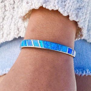 Opal Cuff Bracelet displayed by being worn around a woman's wrist.
