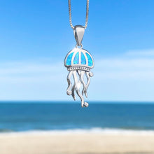 Load image into Gallery viewer, The Opal Don&#39;t Be Jelly Necklace is hanging up close with a blurry beach background.