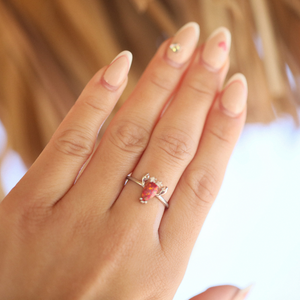 A hand displaying the Opal Lobster Ring.