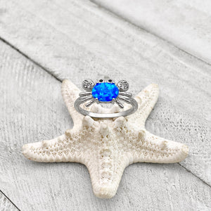 Opal Nautical Crab Ring is placed on top of a white dried artificial starfish.