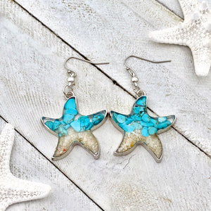 Sand Starfish Earrings in Teal Turquoise are displayed on a white wooden surface.