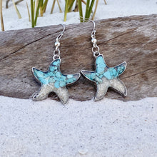 Load image into Gallery viewer, Sand Starfish Earrings in Teal Turquoise are displayed by being placed on top of a driftwood on the sand.