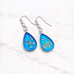 Under the Sea Earrings displayed on a white wooden surface.