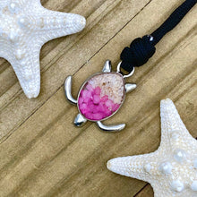 Load image into Gallery viewer, Black Rope Sand Sea Turtle Bracelet in Pink Pebble is displayed on a wooden surface.