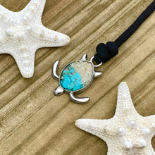 Load image into Gallery viewer, Black Rope Sand Sea Turtle Bracelet in Teal Turquoise is displayed on a wooden surface.