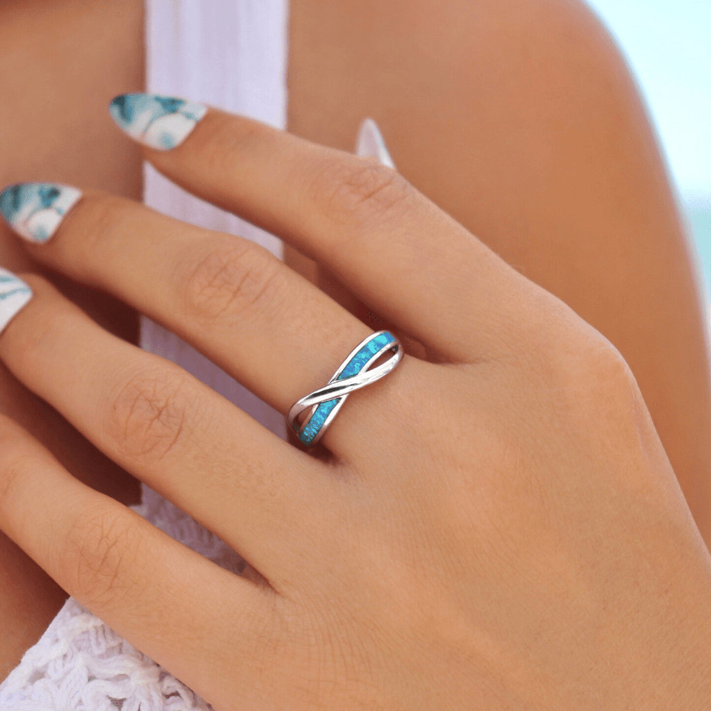 Opal Inlay Twist Wave Ring displayed by being worn on a woman's finger.