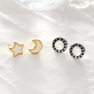 Moonstone Moon Phase and Opal Starry Night Studs are resting on fine sand.