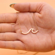Load image into Gallery viewer, Wave Necklace displayed by being held on a woman's palm.