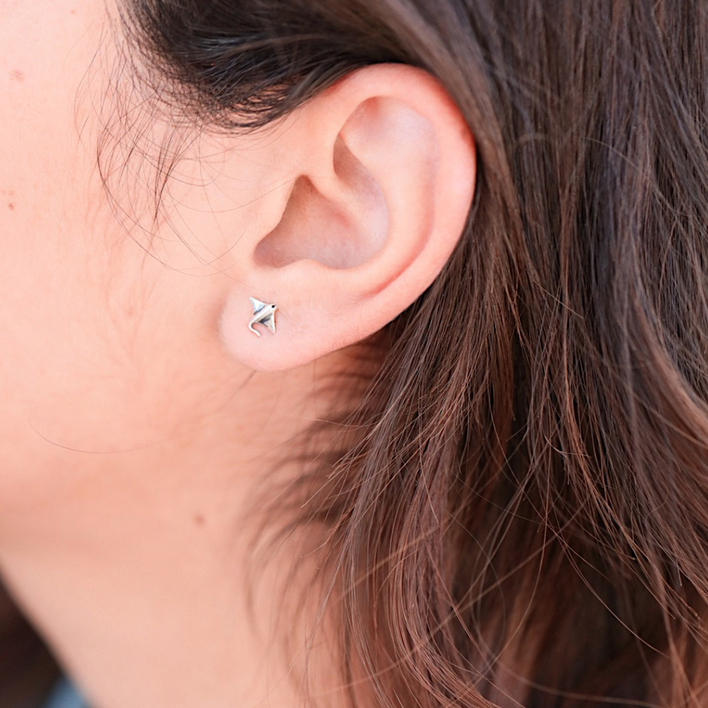 .925 Vintage Sterling Silver Manta Ray Stud is displayed by being worn on a woman's ear.