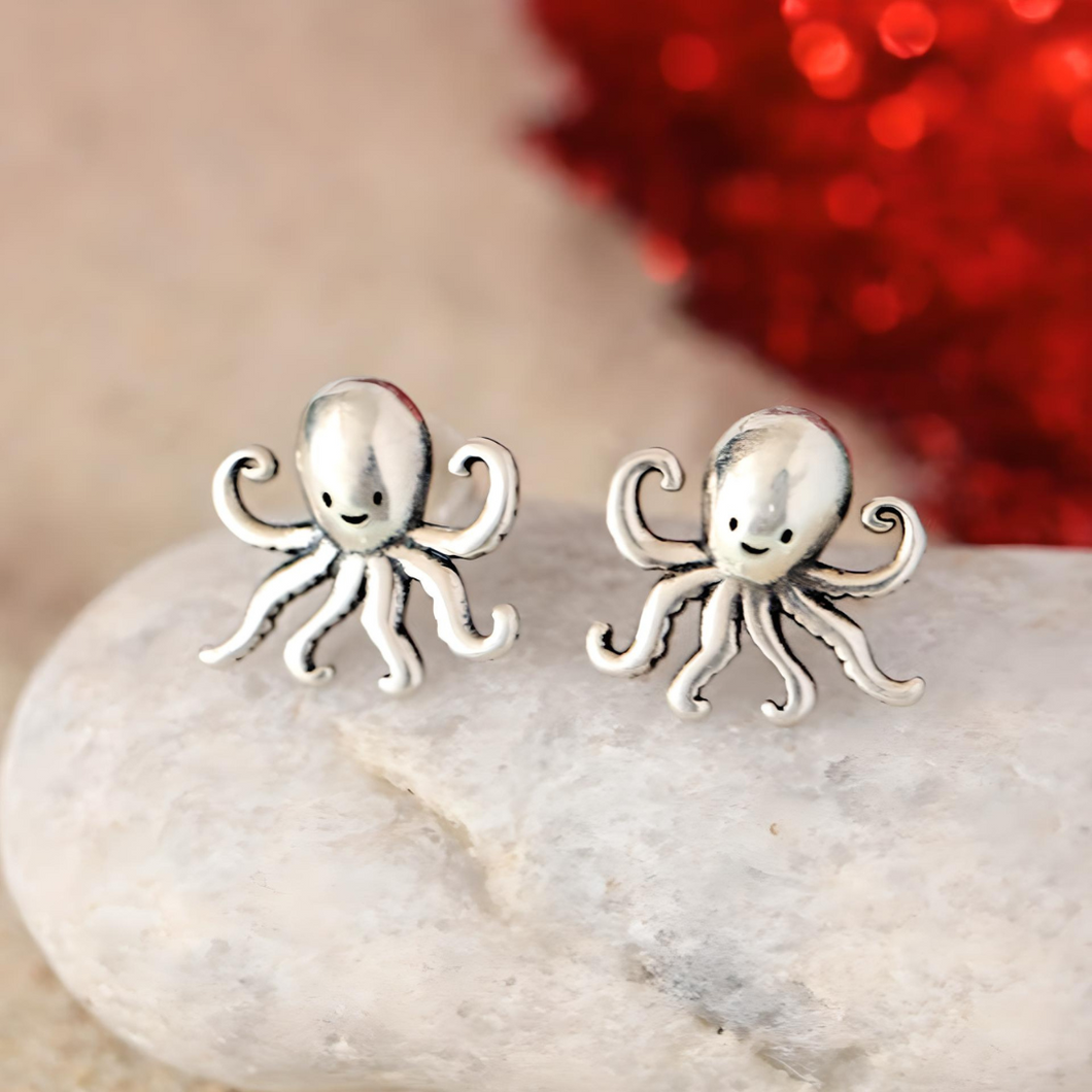 .925 Vintage Sterling Silver Octopus Studs dsiplayed by being placed on a white rock with a blurred background.