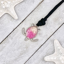 Load image into Gallery viewer, Black Rope Pink Pebble Sand Turtle Bracelet displayed on a white wooden surface.
