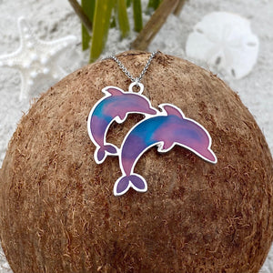 Colorful Enamel Dolphin Necklace displayed on top of a dried coconut.