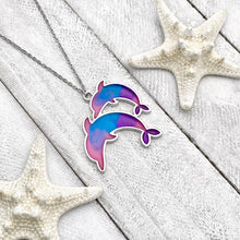 Load image into Gallery viewer, Colorful Enamel Dolphin Necklace displayed on a white wooden surface.