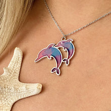 Load image into Gallery viewer, Colorful Enamel Dolphin Necklace displayed by being worn around a woman&#39;s neck.