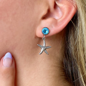 Crystal Stud Starfish Earring displayed by being worn on a woman's ear.