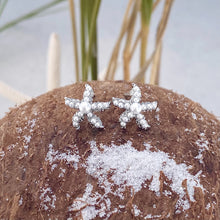 Load image into Gallery viewer, Dainty Pearl Starfish Stud Earrings are showcased on a dried coconut.