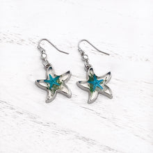 Load image into Gallery viewer, Deep In The Ocean Starfish Earrings 01 displayed on a white wooden surface.