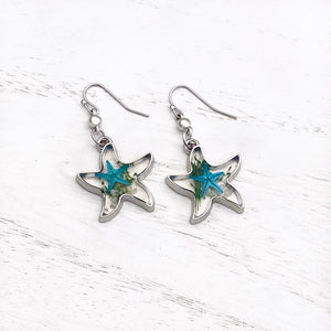 Deep In The Ocean Starfish Earrings 01 displayed on a white wooden surface.