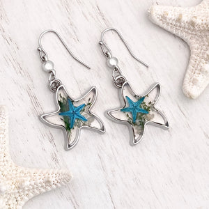Deep In The Ocean Starfish Earrings displayed on a white wooden surface.