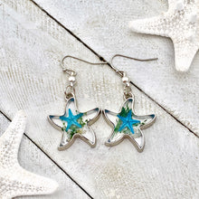 Load image into Gallery viewer, Deep In The Ocean Starfish Earrings displayed on a white wooden surface.