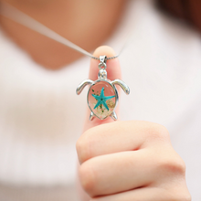 Load image into Gallery viewer, Deep in the Ocean Sea Turtle Necklace displayed up close, positioned by a hand.