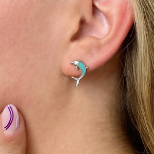 Dolphin Stud Earrings displayed up close by being worn on a woman's ear.