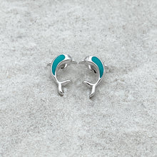 Load image into Gallery viewer, Dolphin Stud Earrings displayed on a white beach sand.