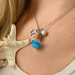 Drift Bottle Anchor Necklace displayed by being worn around a woman's neck.