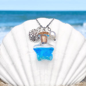 Drift Bottle Sand Dollar Necklace is hung on a big white oyster shell on the beach.