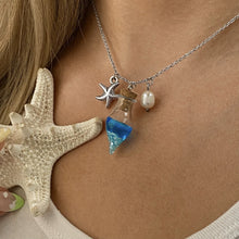 Load image into Gallery viewer, Drift Bottle Starfish Necklace displayed by being worn around a woman&#39;s neck.