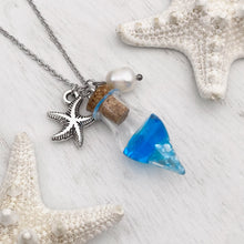 Load image into Gallery viewer, Drift Bottle Starfish Necklace displayed on a white wooden surface.