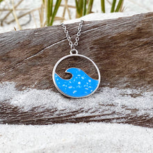 Load image into Gallery viewer, Glittering Wave Necklace is displayed by being placed on top of a driftwood on the sand.