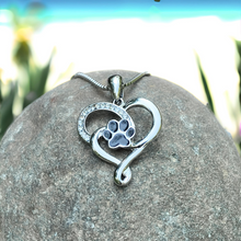 Load image into Gallery viewer, Heart Paw Necklace is placed on top of a rock in a close-up shot.