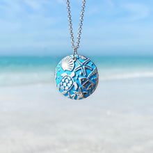 Load image into Gallery viewer, Into the Blue Necklace hanging close for a shot with a blurred beach background.