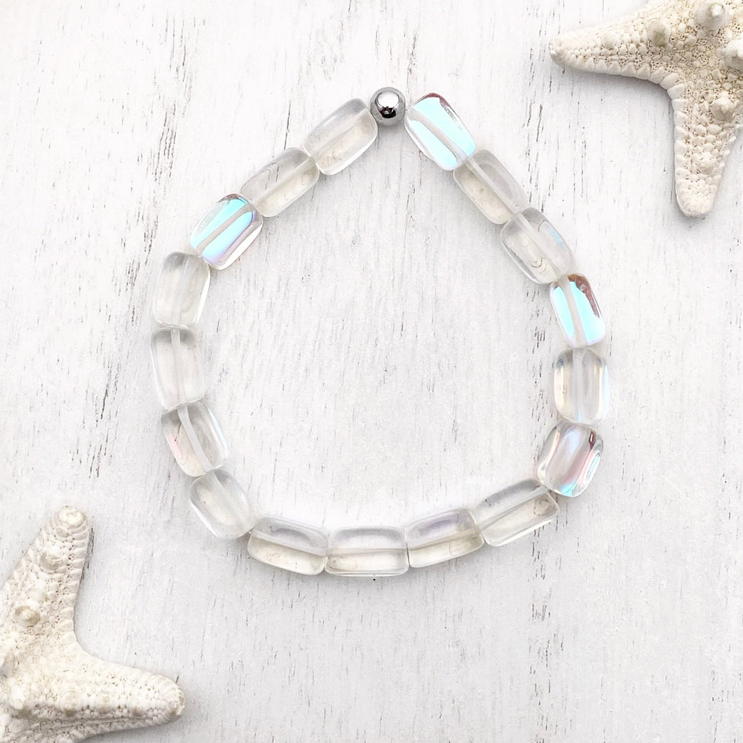 Iridescent Bead Bracelet displayed on a white wooden surface.