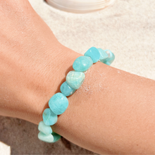 Load image into Gallery viewer, Larimar Bracelet displayed by being worn around a woman&#39;s wrist with a sandy background.