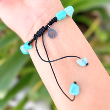 Load image into Gallery viewer, Larimar Bracelet displayed by being worn around a woman&#39;s wrist with a blurred leafy background.