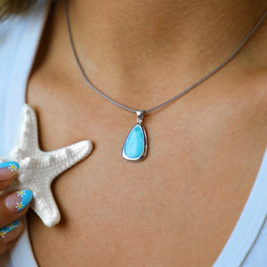 Larimar Drop Necklace displayed closely by being worn around a woman's neck.