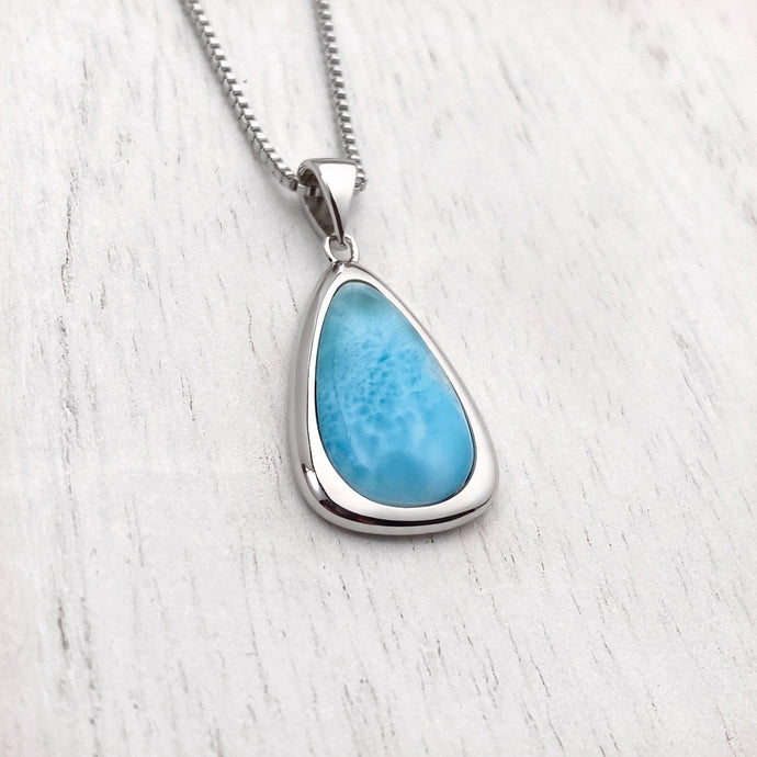 Larimar Drop Necklace displayed on a white wooden surface.