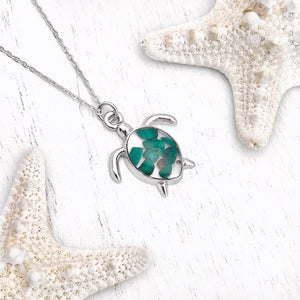 Malachite Sea Turtle Necklace displayed on a white wooden surface.
