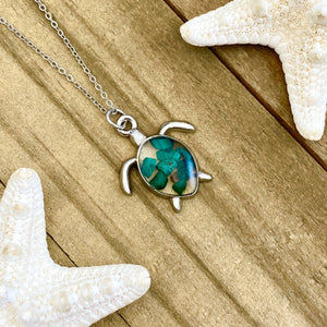 Malachite Sea Turtle Necklace displayed on a wooden surface.