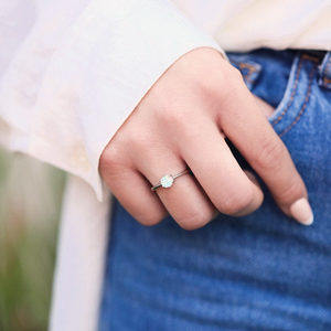 Minimalist Opal Ring is displayed up close by being worn on a woman's hand.