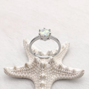 Minimalist Opal Ring displayed by being placed on a white artificial starfish.