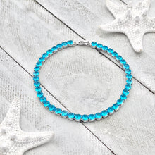Load image into Gallery viewer, Ocean Blue Zircon Tennis Bracelet displayed on a white wooden surface.
