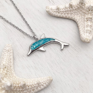 Ocean Treasure Sand Dolphin Necklace displayed on a white wooden surface.